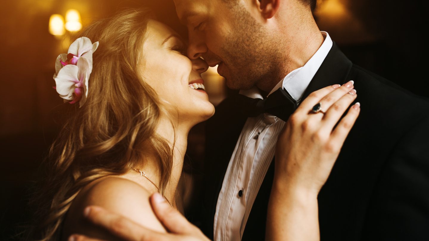 The bride and groom in a cozy house, photo taken with natural light from the window.